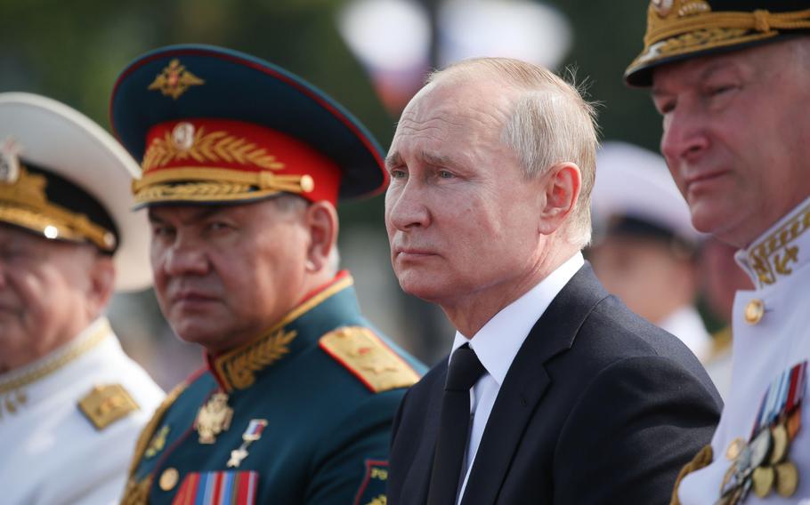 Vladimir Putin, Russia’s president, center, sits alongside Sergei Shoigu, Russia’s defense minister, second left, during the Russian Navy day in St. Petersburg, Russia, on July 28, 2019. 