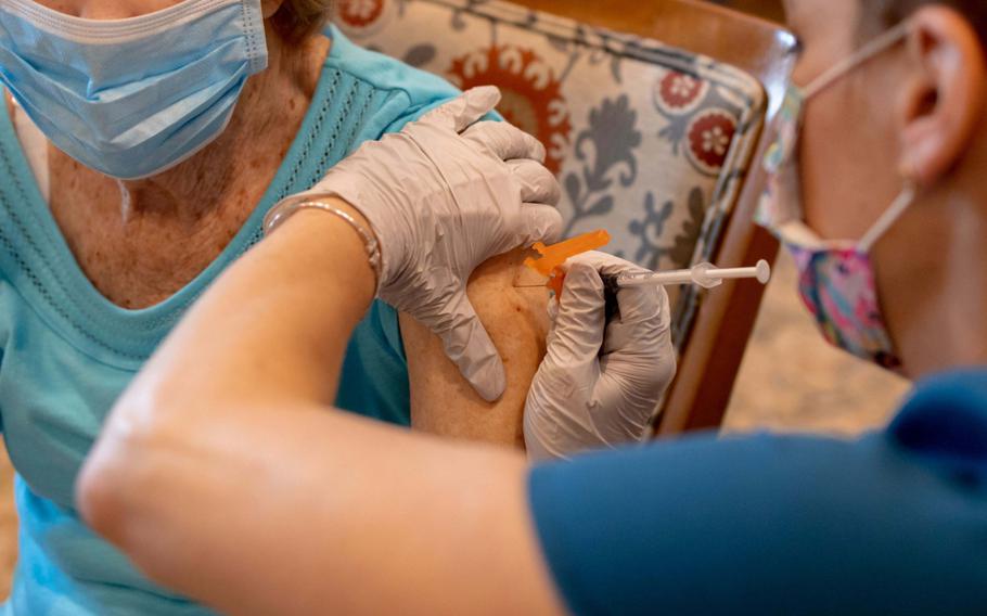 A health care worker administers a third dose of the Pfizer-BioNTech COVID-19 vaccine at a senior living facility in Worcester, Pa., on Aug. 25, 2021. 