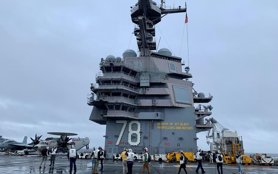 A group embarks aboard the aircraft carrier USS Gerald R. Ford in international waters off the coast of France on Nov. 13, 2022. The Navy’s newest carrier began its maiden deployment after departing its Virginia homeport last month.