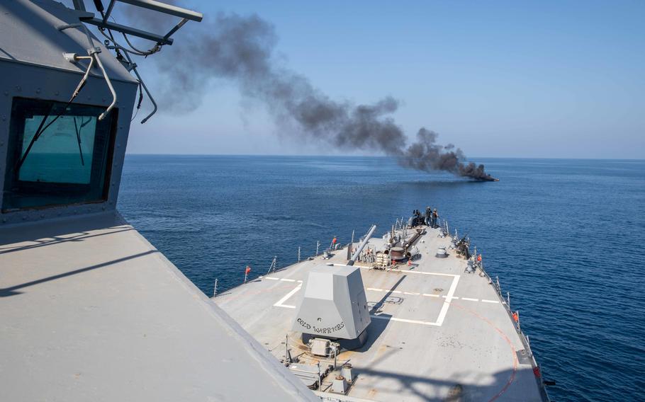 The destroyer USS Nitze approaches a burning motorboat in the Gulf of Aden on Oct. 26, 2022. Sailors rescued three people from the vessel before it sank.