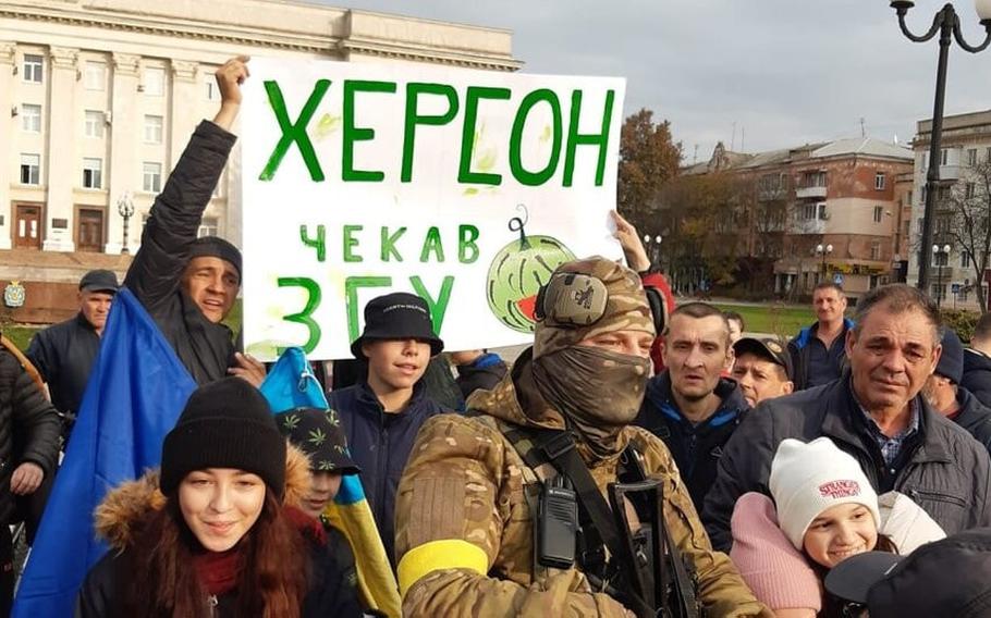 A Ukrainian soldier poses for pictures with citizens of Kherson, Ukraine, on Nov. 11, 2022. 