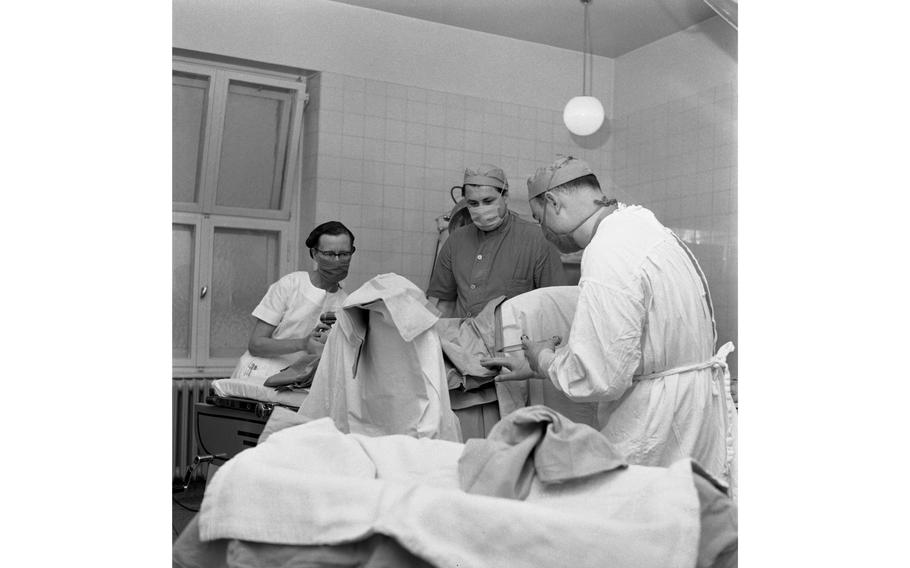 Doctors and nurses perform a procedure in the operating room of the obstetrics and gynecology department at the 97th U.S. Army Hospital in Frankfurt. 