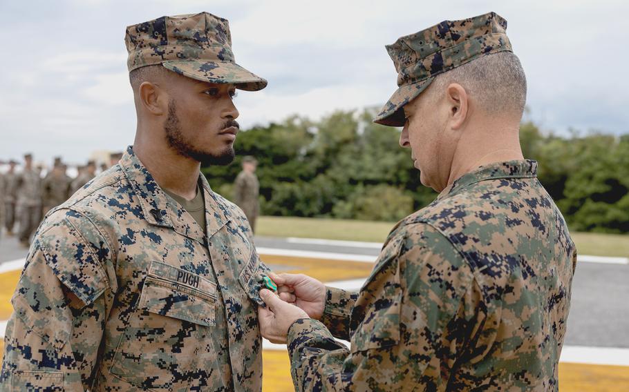Brig. Gen. Adam Chalkley, right, commander of 3rd Marine Logistics Group, presents the Navy and Marine Corps Achievement Medal to Sgt. Malik Pugh at Camp Kinser, Okinawa,Japan, on Dec. 6, 2023.