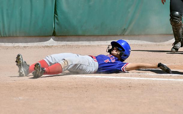 Ramstein runner Amaya Calderon reaches back to touch home plate after missing it during the second game of a doubleheader against Stuttgart on May 10, 2025, at the Stuttgart Reds Softball Field in Stuttgart, Germany.