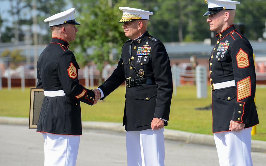 Marine Raider Staff Sgt. Nicholas Jones is presented the Navy Cross by Gen. David Berger, the Marine Commandant, on Thursday, Aug. 26 at Camp Lejeune, as Sgt. Maj. of the Marine Corps Troy Black looks on. Jones, a member of the elite 2nd Marine Raider Battalion was awarded the nation’s second highest medal for battlefield heroics for his actions in a deadly fight with Islamic State group militants in Iraq in March 2020. 