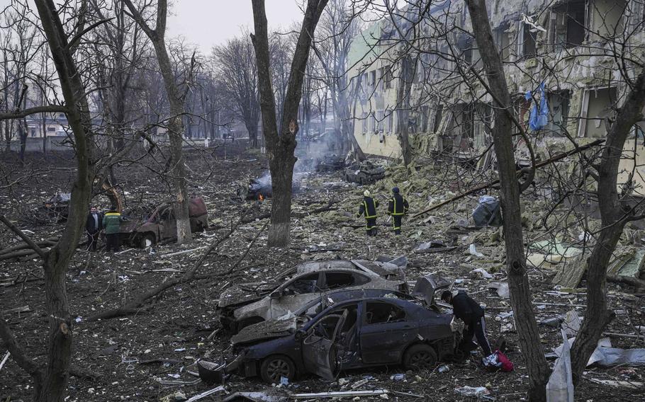 Ukrainian emergency employees work at the side of the damaged maternity hospital in Mariupol, Ukraine, on Wednesday, March 9, 2022. A Russian attack has severely damaged a maternity hospital in the besieged port city of Mariupol, Ukrainian officials say. 