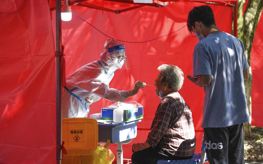 A medical worker takes a swab sample from a resident for nucleic acid test at a community testing site for COVID-19 in Yunyan District of Guiyang, southwest China’s Guizhou Province, Sept. 5, 2022. 