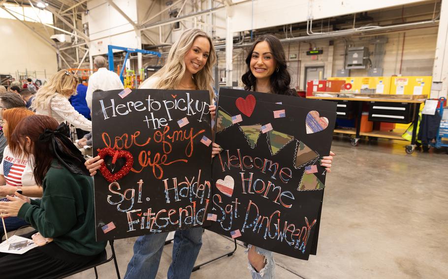 Family members of Task Force Tomahawk soldiers hold up signs at the welcome home ceremony at Will Rogers Air National Guard Base in Oklahoma City, Saturday, Feb. 24, 2024. 