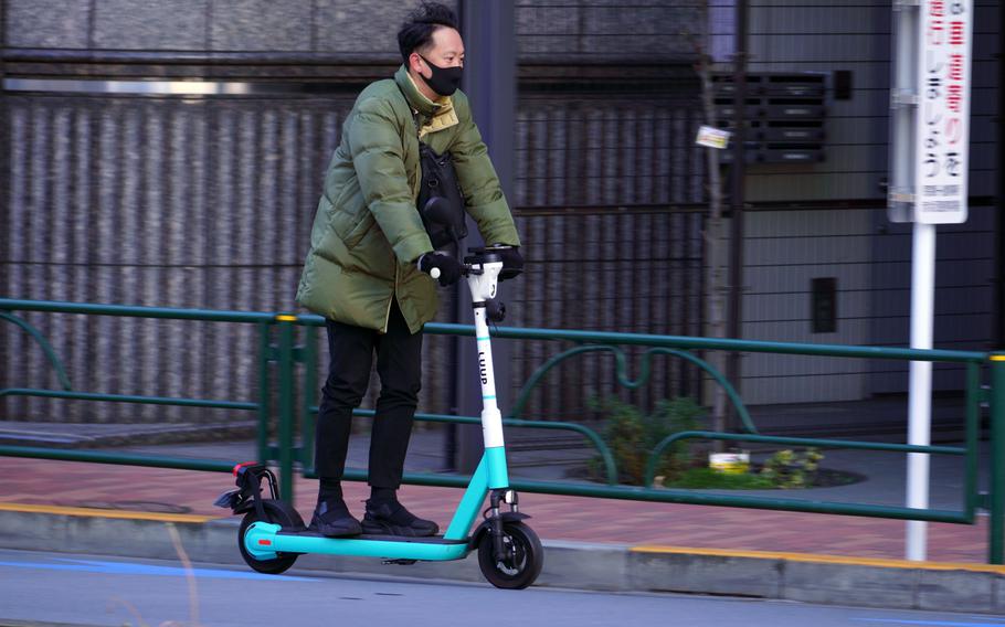 A man rides a rented electric scooter in Tokyo, Jan. 25, 2023.