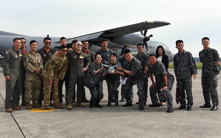 Airmen from the 36th Airlift Squadron and members of the Japan Air Self-Defense Force pose ahead of an orientation flight at Yokota Air Base in western Tokyo, May 26, 2023. 