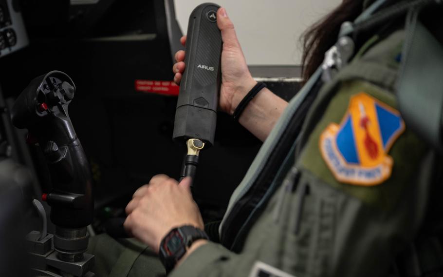 A person seated in an aircraft holding a device.