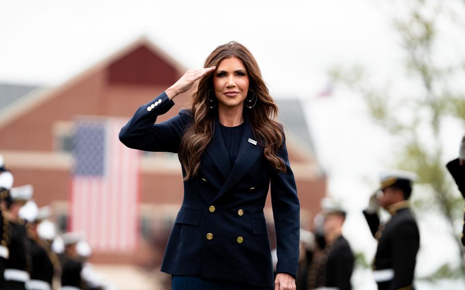 Kristi Noem walking and saluting.