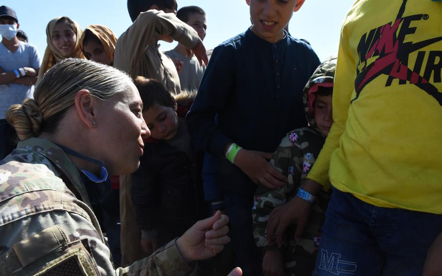 Air Force Col. Amy Glisson kneels down to speak with a child inside the temporary living facilities at Ramstein Air Base, Germany, for evacuees from Afghanistan, Sept. 2, 2021. Glisson, the 86th Mission Support Group commander at Ramstein, is the camp commander for the day-to-day operations of receiving, housing and sending tens of thousands of evacuees on to the United States.