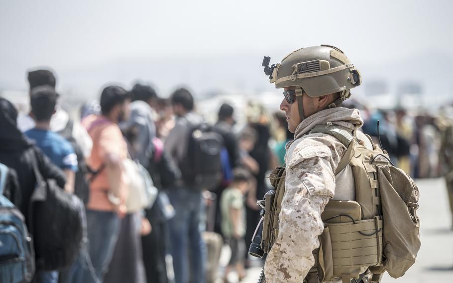 In this Aug. 22, 2021, image provided by the U.S. Marine Corps, a Marine with Special Purpose Marine Air-Ground Task Force-Crisis Response-Central Command provides assistance during an evacuation at Hamid Karzai International Airport in Kabul, Afghanistan. 