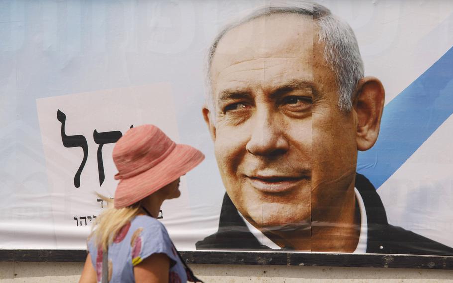 A pedestrian passes an election campaign billboard for Benjamin Netanyahu, Israel’s prime minister and the leader of the Likud party, in Tel Aviv, Israel, on March 15, 2021.