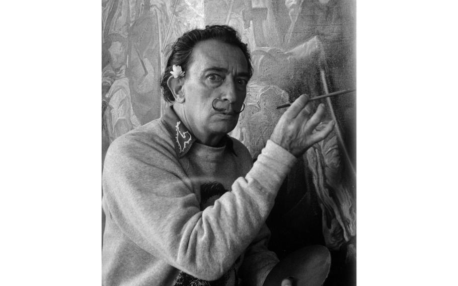 Surrealist painter Salvador Dali poses in front of his latest work titled "The Battle of Tetuan." The painting is based on a battle between the Moors and the Spanish in 1860 at Tetuan near Tangier, Morocco.