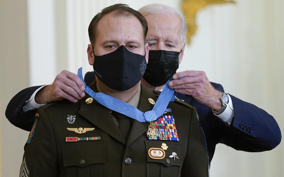 President Joe Biden presents the Medal of Honor to Army Master Sgt. Earl Plumlee for his actions in Afghanistan on Aug. 28, 2013, during an event in the East Room of the White House, Thursday, Dec. 16, 2021, in Washington. 