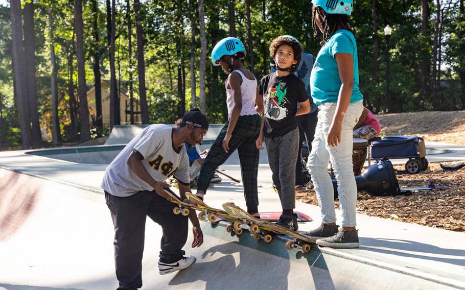 A man teaches kids to skateboard in an Irmo, S.C., skate park. 
