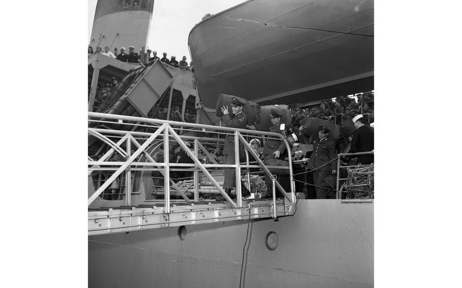 Pvt. Elvis Presley walks off the gangway of the USS Randall in Bremerhaven, Germany, to the sound of hundreds of screaming teenage fans. 