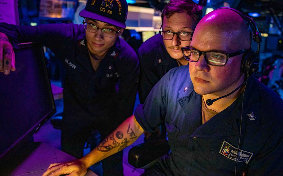 Sailors stand watch in the combat information center aboard the USS Chancellorsville as the guided-missile cruiser sails through the Taiwan Strait, Sunday, Aug. 28, 2022.