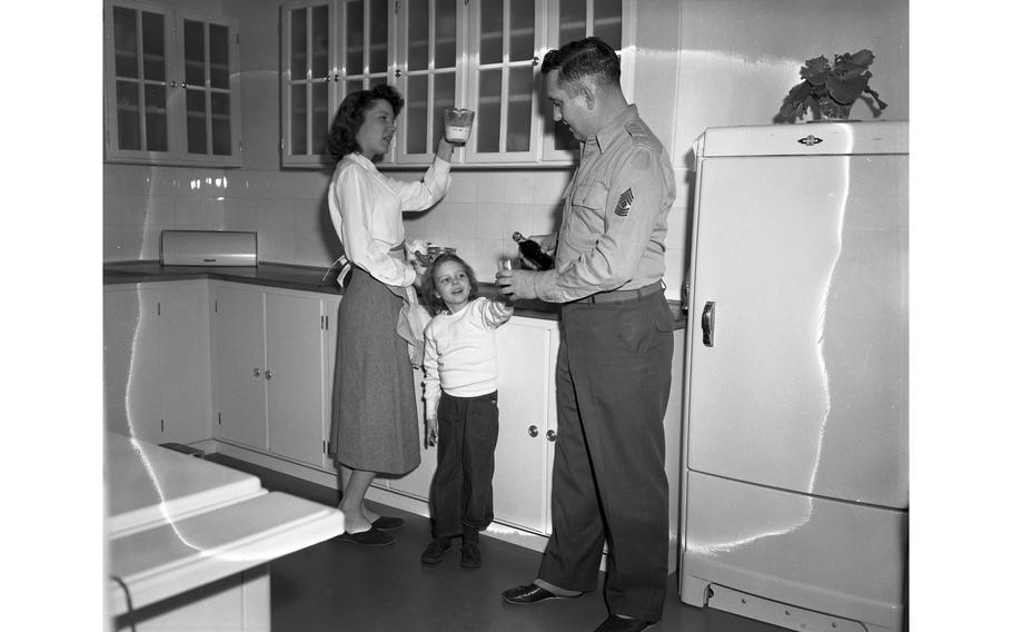 1st Sgt. Thomas H. Fay, of H Co., 18th Inf., 1st Div., his wife Betty Jo and their 5-year-old daughter Colleen stand in the kitchen of their brand new apartment in the Aschaffenburg military housing complex. Sgt. Fay pours his daughter a soda, as Mrs. Fay measures ingredients to bake a cake.