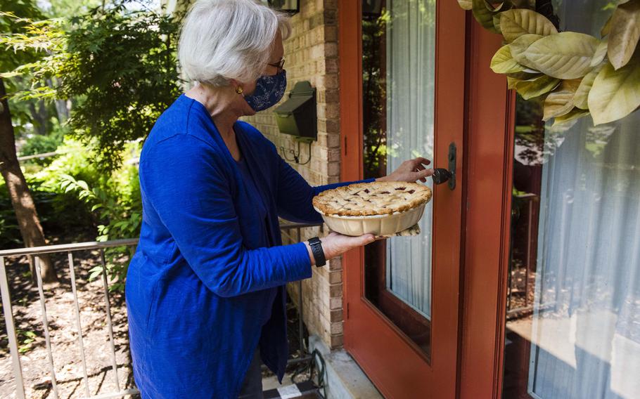 Betty Douglass, 80, drops off a cherry pie Friday for daughter Kim Marin's 51st birthday at her home, while Marin and her daughter are self-isolating.