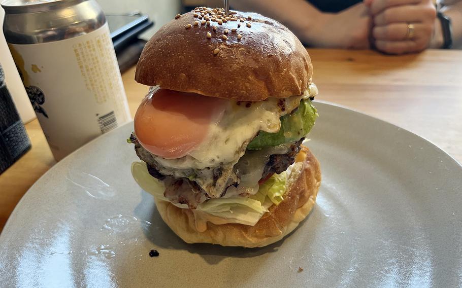 A burger is stacked high with toppings, including a fried egg.