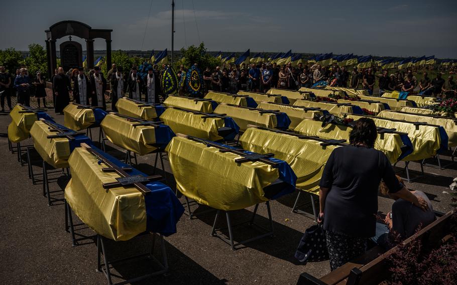 The caskets of 27 Ukrainian service members who died fighting the Russians are draped in Ukrainian flags during their funeral on June 3. 