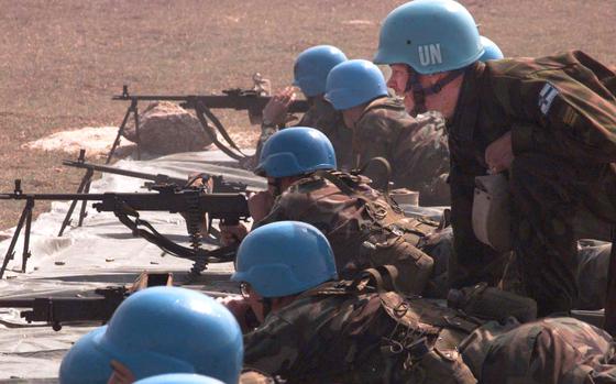 Petrovec, Macedonia, March 28, 1998: A Finnish officer shouts instructions as Americans test fire Finnish rifles during a live fire exercise Saturday near Skopje airport in Macedonia. Americans, most of them from Schweinfurt, Germany, make up 350 of the 750 United Nations peacekeepers patrolling Macedonia. Their patrols border the volatile Kosovo regioin of Serbia, but the U.S. troops say their mission is to monitor the border, not get involved in potential combat. 

Read Stars and Stripes' article on the 1998 Macedonian mission here. https://www.stripes.com/news/macedonia-mission-dimmed-by-other-balkan-efforts-1.283664

META TAGS; peacekeeping; NATO; U.S. Army; patrol; 