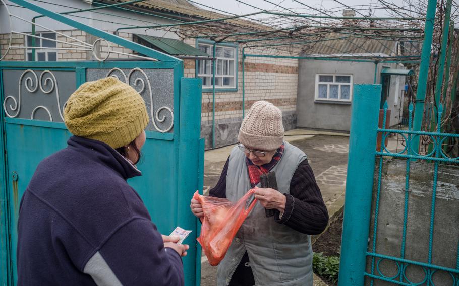 Alla Kravtsova, 55, sells a chicken to her neighbor, Helena Horobets, 72, in Tiahynka.