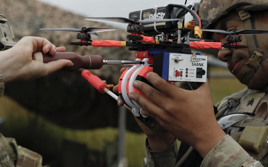 Two soldiers prepare an armed drone.