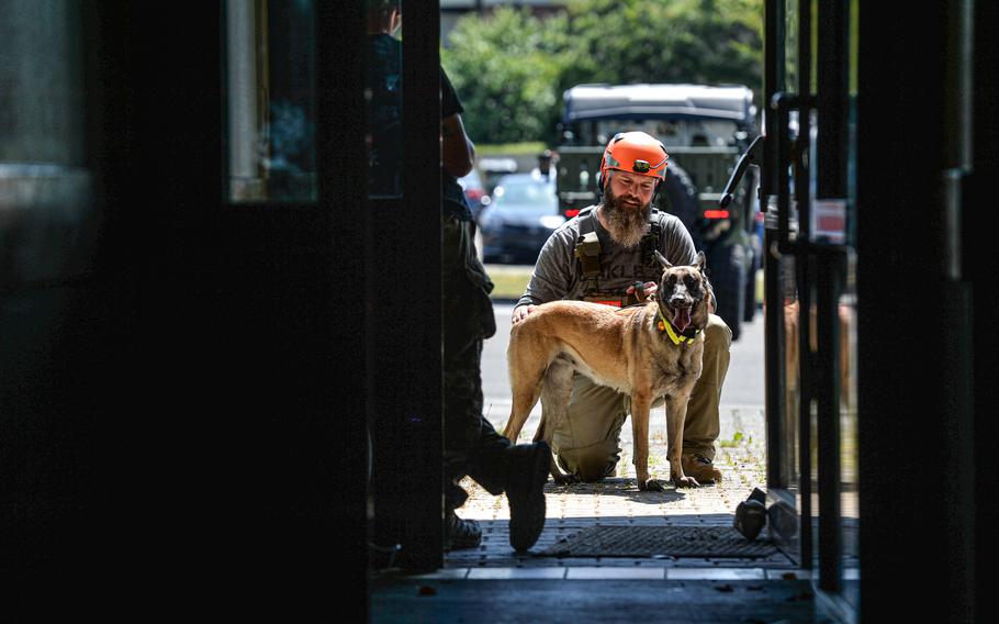 A fire rescue team member from the German city of Trier prepares his dog Beskar to search a building during a training session at Spangdahlem Air Base, Germany, on June 26, 2024.