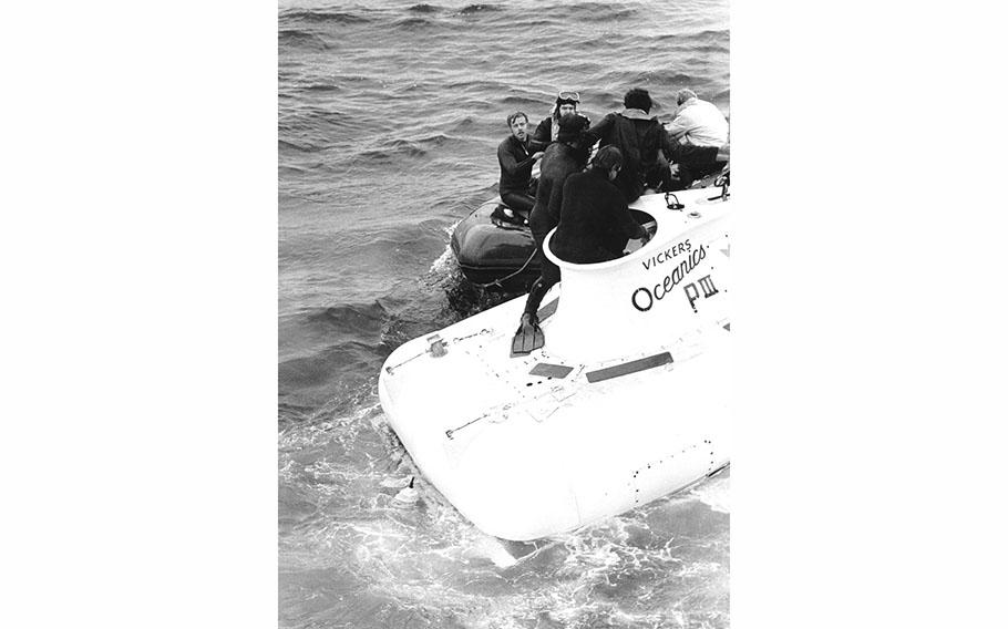 Divers assist rescued pilots from the Canadian submersible Pisces III in September 1973.