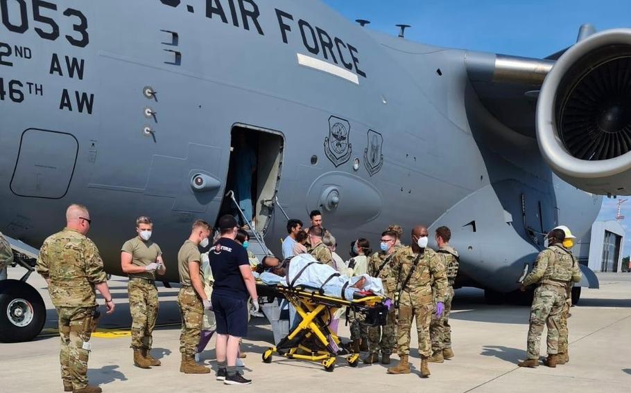 Airmen from the 86th Medical Group help an Afghan mother and family off a U.S. Air Force C-17, call sign Reach 828, moments after she delivered a child aboard the aircraft upon landing at Ramstein Air Base, Germany, Aug. 21, 2021.