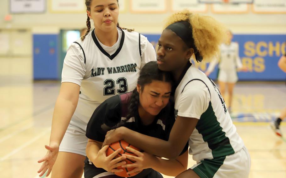 Zama's Kierstyn Aumua and Daegu's Jasmirra McClendon tie up for the ball as the Warriors' Jazmine Harvey moves in to help. The Trojans won 36-31.