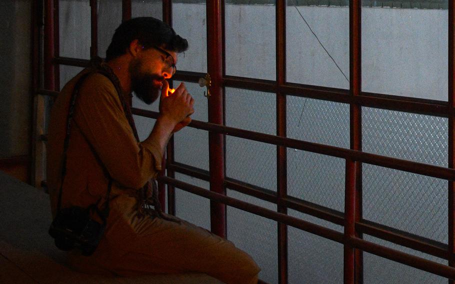 Chris Jones, who fought in Helmand province during two tours as a Marine, lights a cigarette as he watches the sun set on a return trip to the province in 2019. Jones said the process of trying to help evacuate Afghans who worked with the U.S. government brought back memories of his time in Afghanistan, along with feelings of helplessness and regret for not being able to save people. 