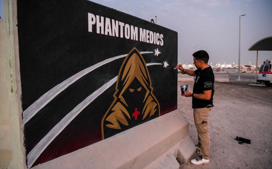 U.S. Army Sgt. Anthony Castillo, a mobility specialist assigned to the 3-157th Field Artillery unit and Colorado National Guard, touches up a mural he painted for the 380th Expeditionary Medical Squadron, Sept. 15, 2022, at Al Dhafra Air Base, United Arab Emirates. The wall features “the Phantom Medic” (the unit’s adopted logo) and F-22 Raptor silhouettes — which made frequent appearances in Al Dhafra’s skies after the missile attack on Jan. 17, 2022.