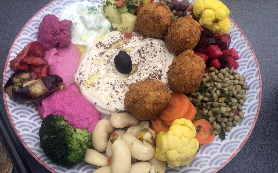 The vegetarian falafel plate with hummus and salads as served at the Hamburger am Turm in Frankfurt, Germany. Among the salads were potato, apple and beet, and lentil. White beans, various vegetables and a sharp horseradish-beet cream were among the other things served with this delicious dish, along with flatbread.