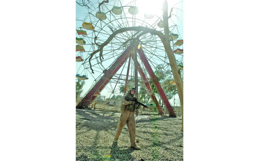 A Marine walks beneath a Ferris wheel in Fallujah. The men of 1st Platoon, Weapons Company, 1st Battalion, 25th Marines were looking for weapons and explosives. 