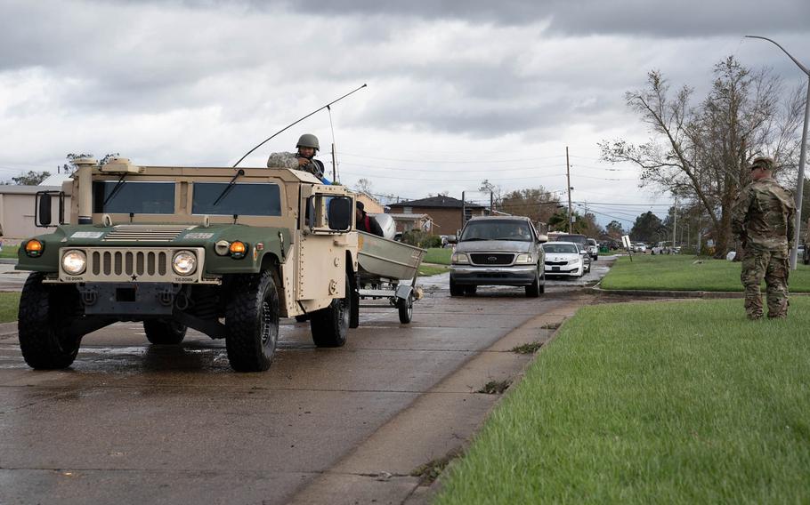 Louisiana National Guard members in high-water vehicles and boats work with St. John the Baptist Parish officials to rescue people stranded in their homes in the wake of Hurricane Ida.