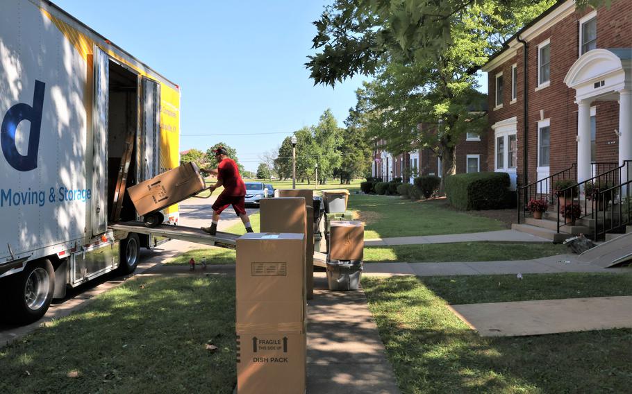 A man uses equipment to move household items into a truck.