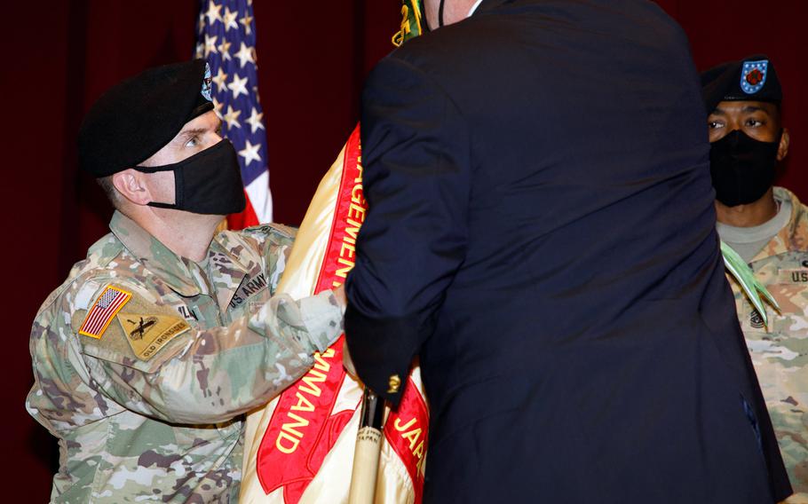 Col. Christopher Tomlinson accepts the U.S. Army Garrison Japan flag during a change-of-command ceremony at Camp Zama, Japan, Tuesday, July 20, 2021. The outgoing commander, Col. Thomas Matelski, is moving to Indo-Pacific Command in Hawaii to become chief of the Civil Affairs Planning Team, J9.