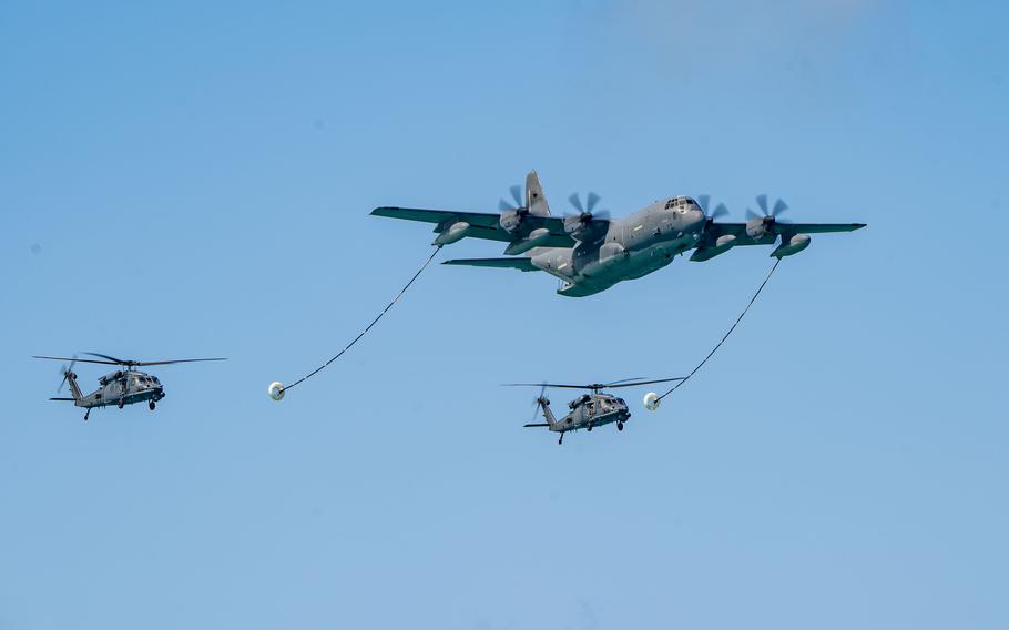 An aircraft and two helicopters simulate a helicopter air-to-air refueling demonstration 