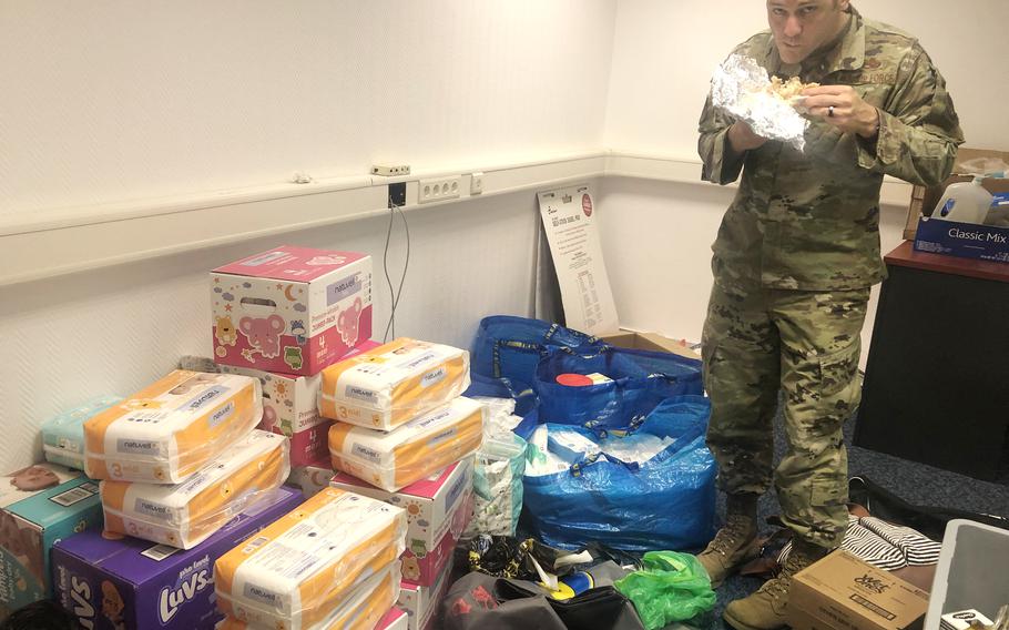 Andrew Wilder, an Air Force first sergeant, takes a late-night bite to eat in a room filled with toiletries and baby items donated at Ramstein Air Base in Germany, August 19, 2021. Donations were collected within hours for evacuees who could arrive at the base from Afghanistan.