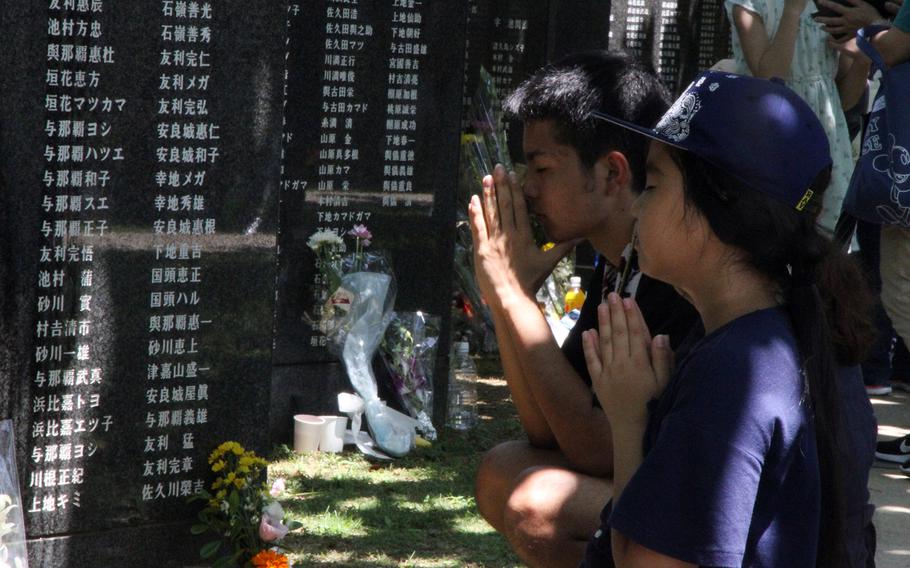 Children pray for those killed in the Battle of Okinawa during the island's annual Irei no Hi ceremony on June 23, 2018.