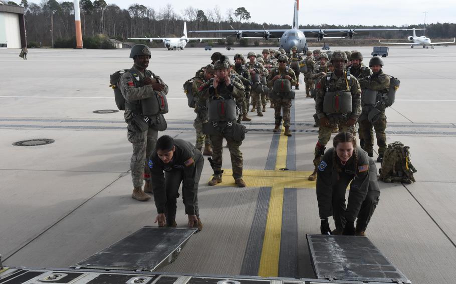 Senior Airman Marissa Antillonloya, left, and Staff Sgt. Devyn Freeze, loadmasters with the 37th Airlift Squadron at Ramstein Air Base, Germany, prepare a C-130J to board Army paratroopers for a training mission on March 18, 2022.