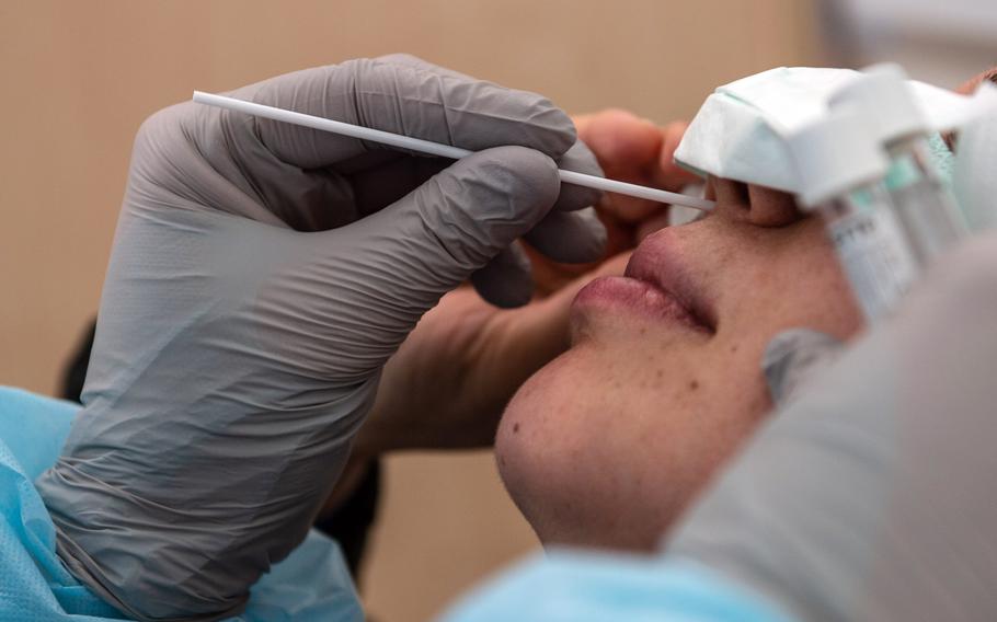 A patient is tested for the coronavirus at the COVID-19 clinic at Landstuhl Regional Medical Center, Germany, in 2020. Although Germany will end free coronavirus testing for residents in October, the U.S. military in the country will continue offering coronavirus tests to eligible beneficiaries.