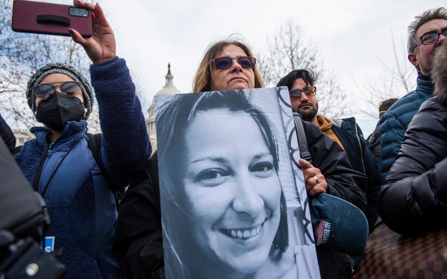 A demonstrator holds a photo of Ashli Babbitt at a news conference outside the U.S. Capitol in Washington, D.C., on Jan. 6, 2022. Babbitt was fatally shot by Capitol Police during the riot at the Capitol a year earlier.