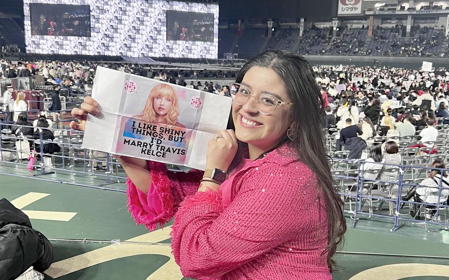 Jacqueline Ochoa Luna, a civlian worker at Yokota Air Base, poses inside Tokyo Dome with a Taylor Swift poster she made for The Eras Tour, Wednesday, Feb. 7, 2024. 