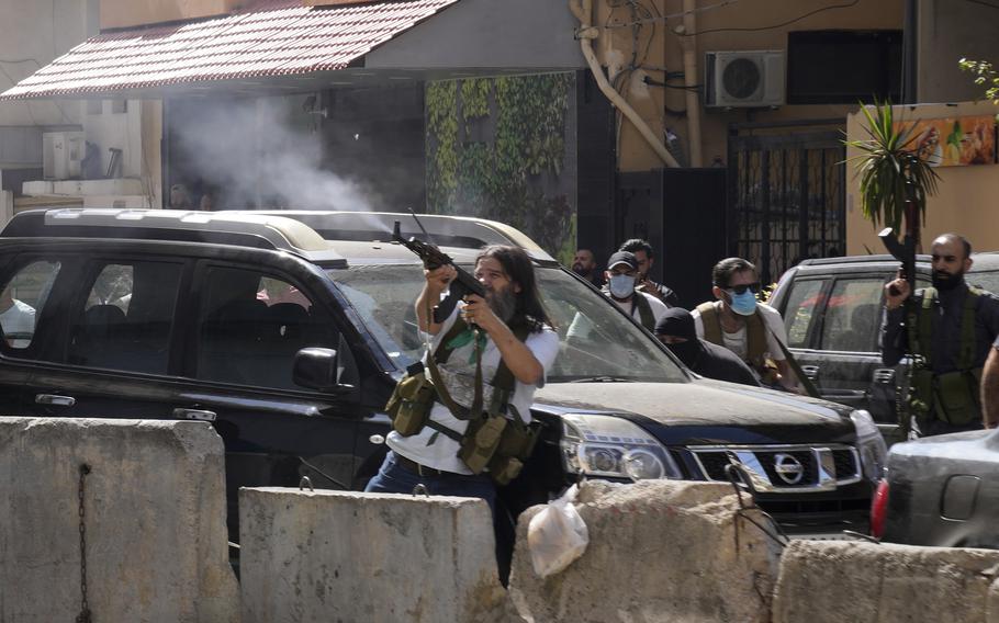Supporters of a Shiite group allied with Hezbollah fire weapons during armed clashes that erupted during a protest in the southern Beirut suburb of Dahiyeh, Lebanon, Thursday, Oct. 14, 2021. It was not immediately clear what triggered the gunfire, but tensions were high along a former civil war front-line between Muslim Shiite and Christian areas.